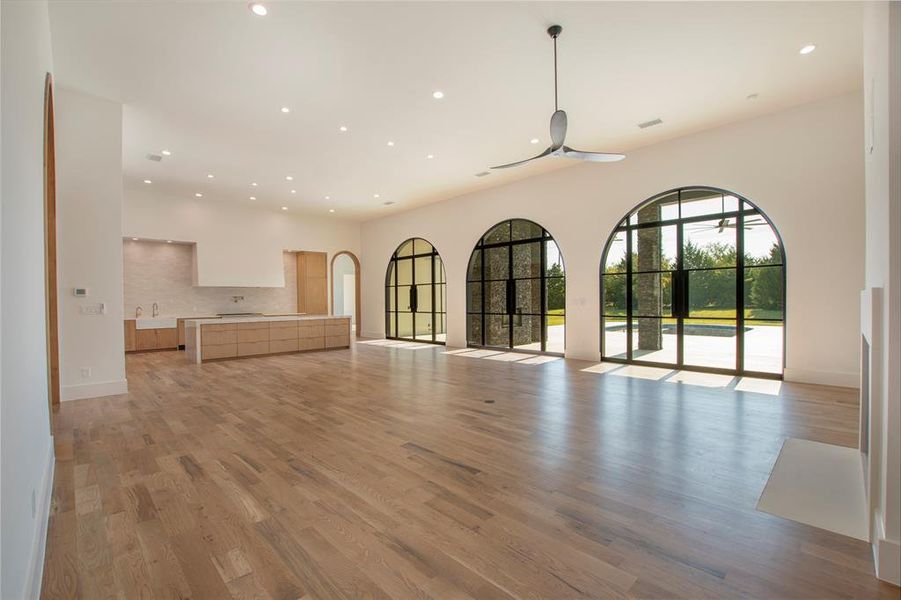 Unfurnished living room featuring sink and light wood-type flooring