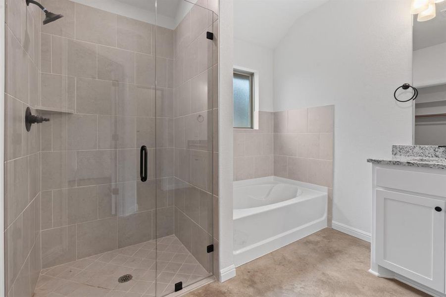 Bathroom featuring vanity and shower with separate bathtub