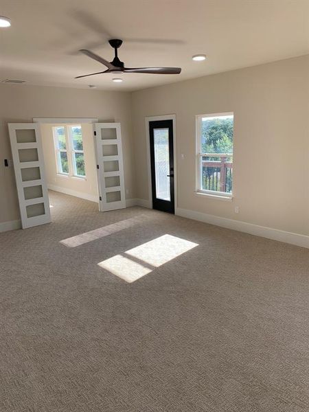 Gameroom with french doors, ceiling fan, light colored carpet, and a wealth of natural light