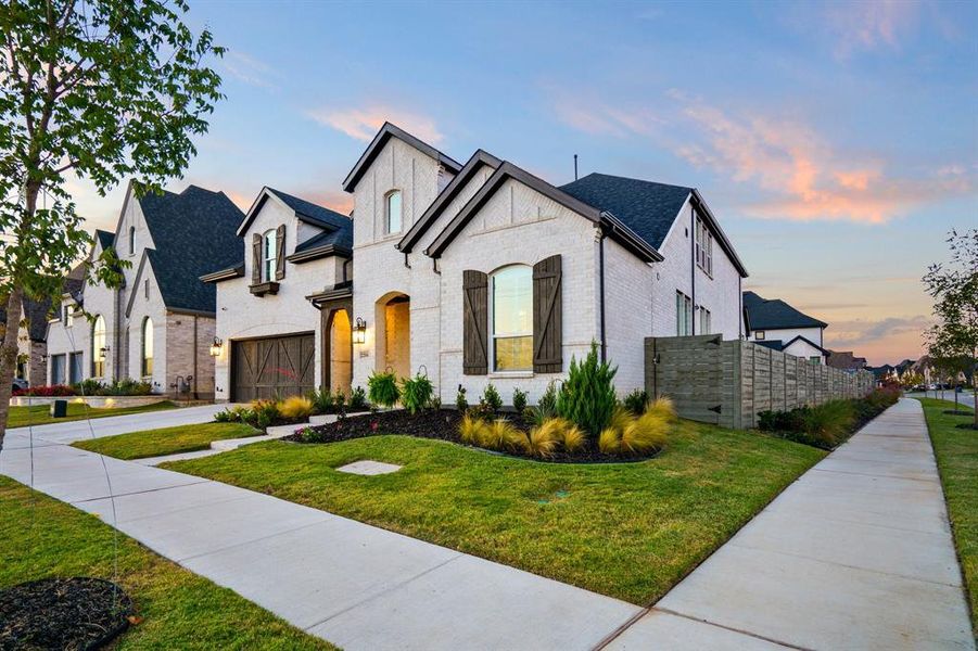 French country inspired facade with a yard