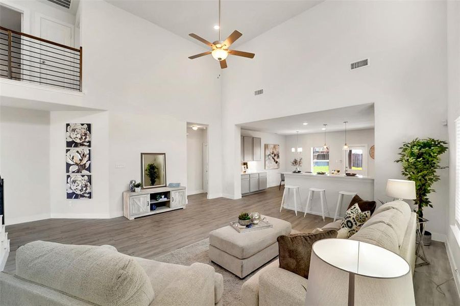 Living room with high vaulted ceiling, ceiling fan, and hardwood / wood-style floors