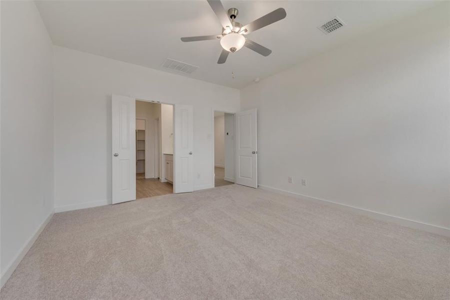 Unfurnished bedroom featuring light colored carpet and ceiling fan