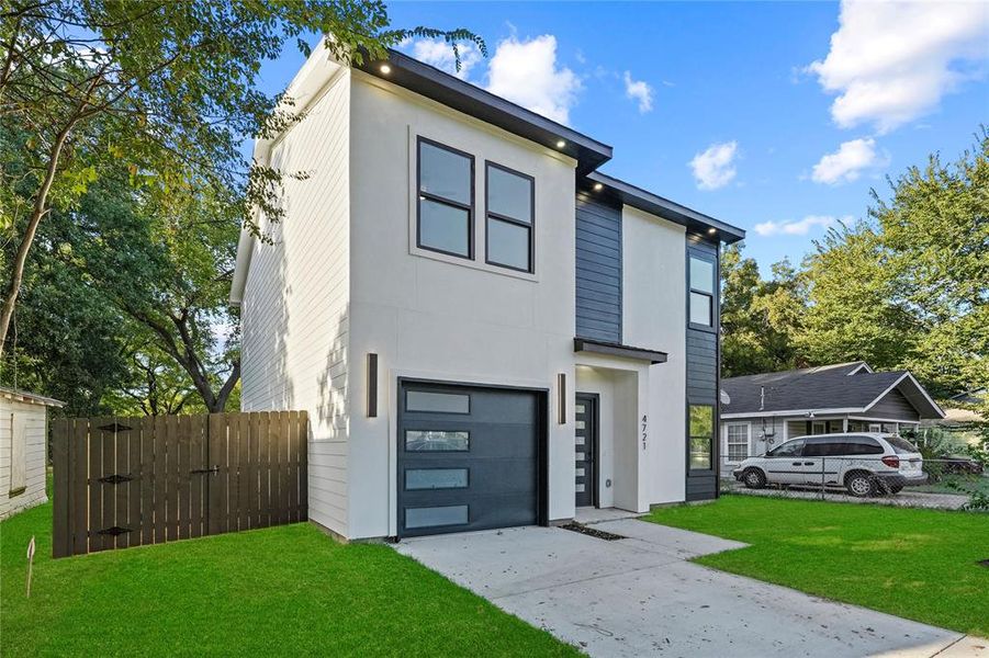 Contemporary home featuring a front lawn and a garage