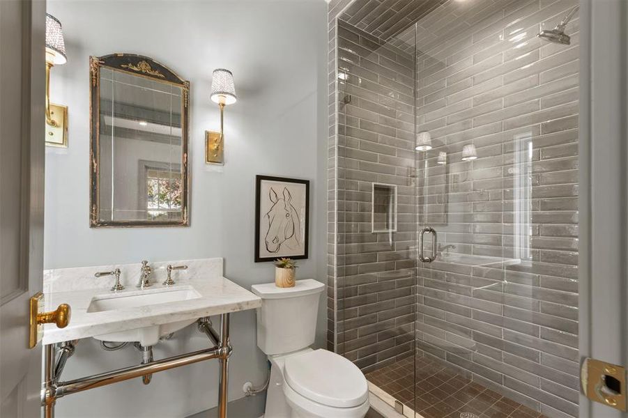 Bathroom featuring sink, an enclosed shower, and toilet