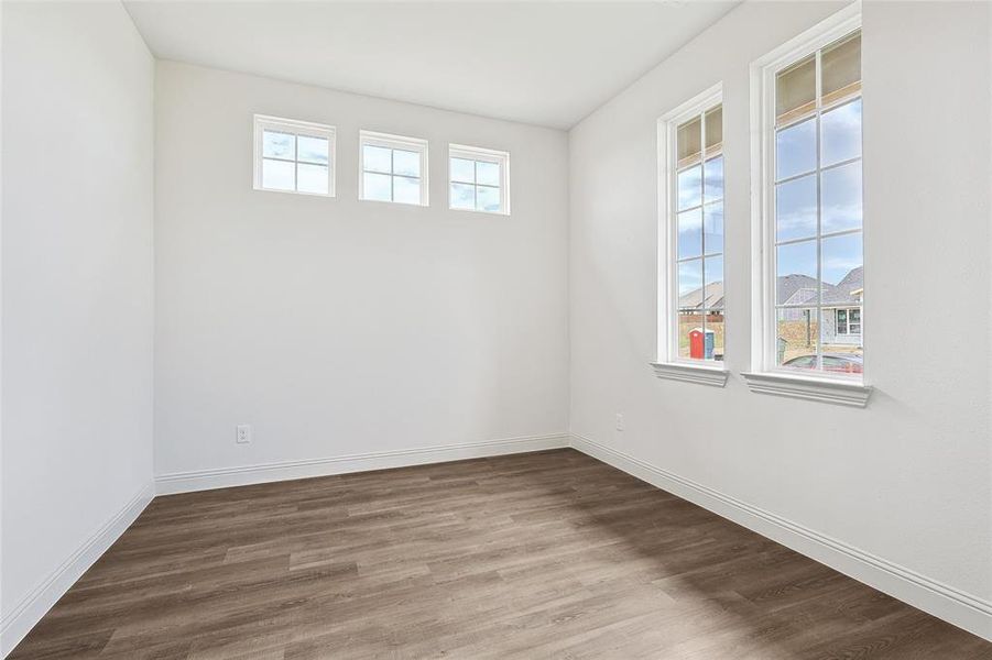 Unfurnished room featuring wood-type flooring and plenty of natural light