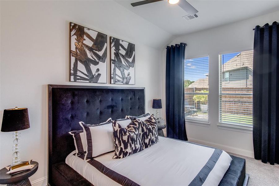 Bedroom featuring carpet floors, ceiling fan, and vaulted ceiling