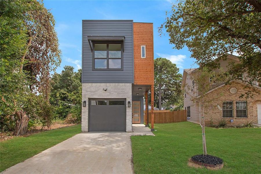 View of front of home with a front yard and a garage