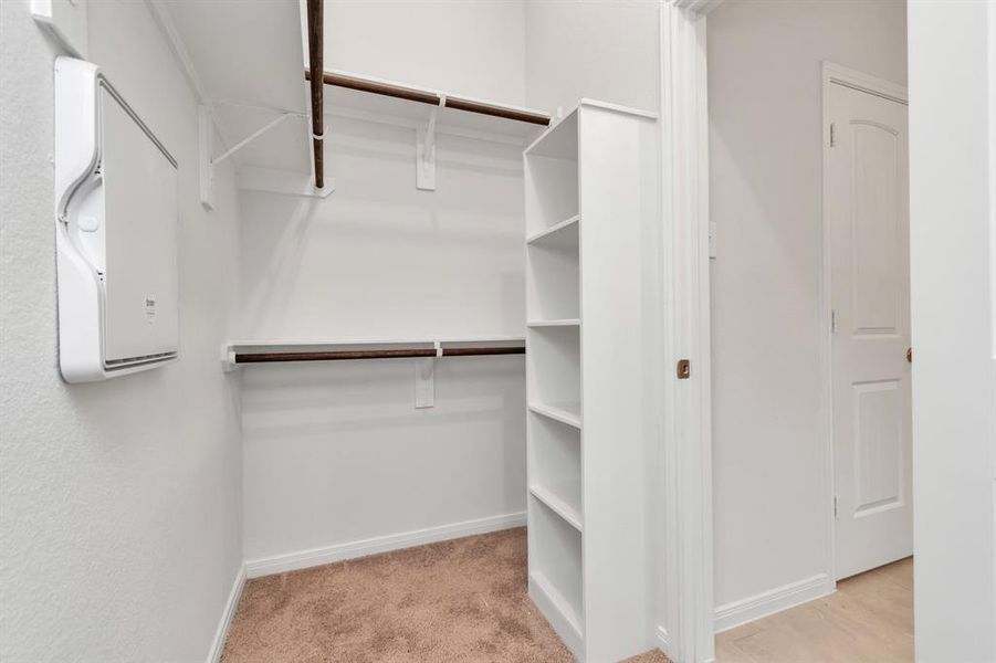 Maximize your storage in this spacious walk-in closet, equipped with built-in shelving and hanging rods. Whether you need space for seasonal clothing or extra linens, this closet provides the versatility and convenience you need. **This image is from another Saratoga Home - Clover floorplan.**