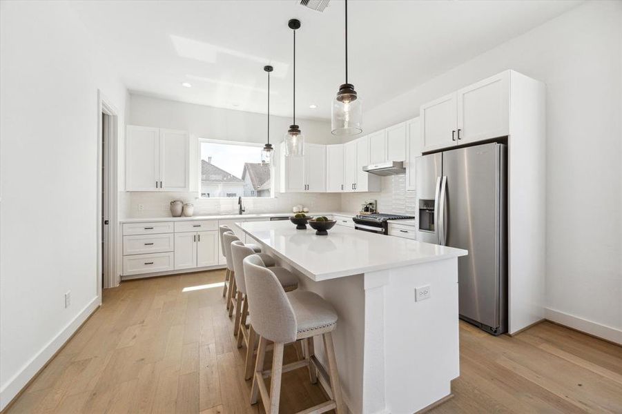 Walk in pantry in the corner of this lovely kitchen. Half bath for guests to the left.