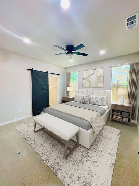 Carpeted bedroom with ceiling fan and a barn door