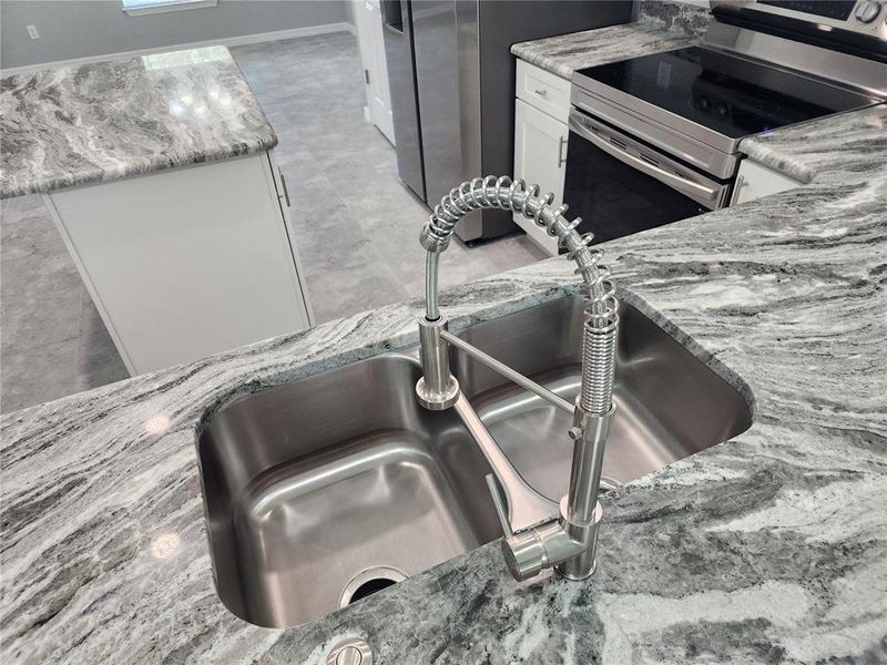 Granite countertops with an undermounted kitchen sink and pull-out faucet