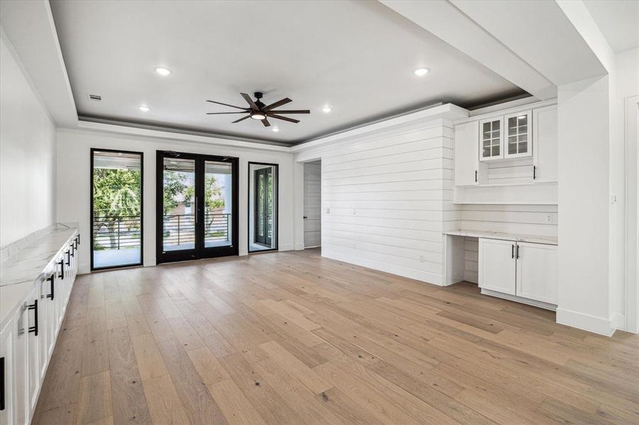 This expansive game room features built-ins on either side, providing storage to keep toys and essentials neatly hidden. With 8 ft aluminum glass double doors that open to the balcony, it connects indoor and outdoor living, creating a perfect space for fun on the second floor!