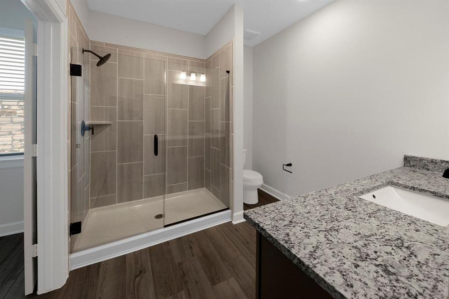 With its expansive layout, the en-suite bathroom boasts a stunning walk-in shower as its centerpiece, showcasing sleek, modern design elements and premium fixtures that elevate the space to a new level of aesthetic elegance.