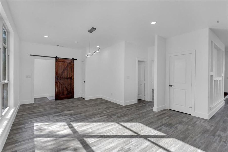 Empty room featuring dark hardwood / wood-style floors and a barn door