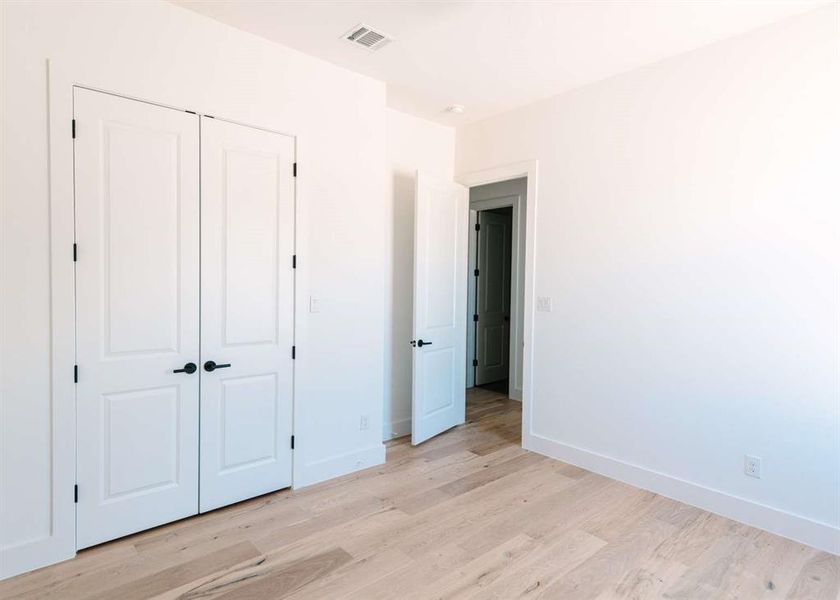 Unfurnished bedroom featuring light hardwood / wood-style floors and a closet