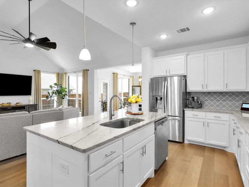 Kitchen featuring light hardwood / wood-style flooring, ceiling fan, stainless steel appliances, decorative light fixtures, and sink