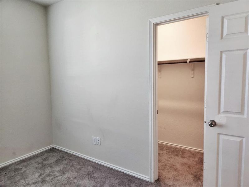 Primary bedroom walk-in closet runs the length of the wall