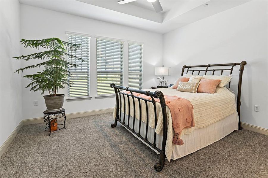 Carpeted bedroom featuring ceiling fan