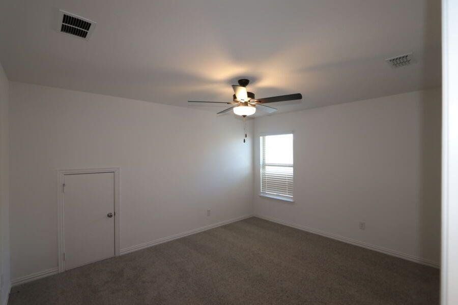 Carpeted spare room with ceiling fan