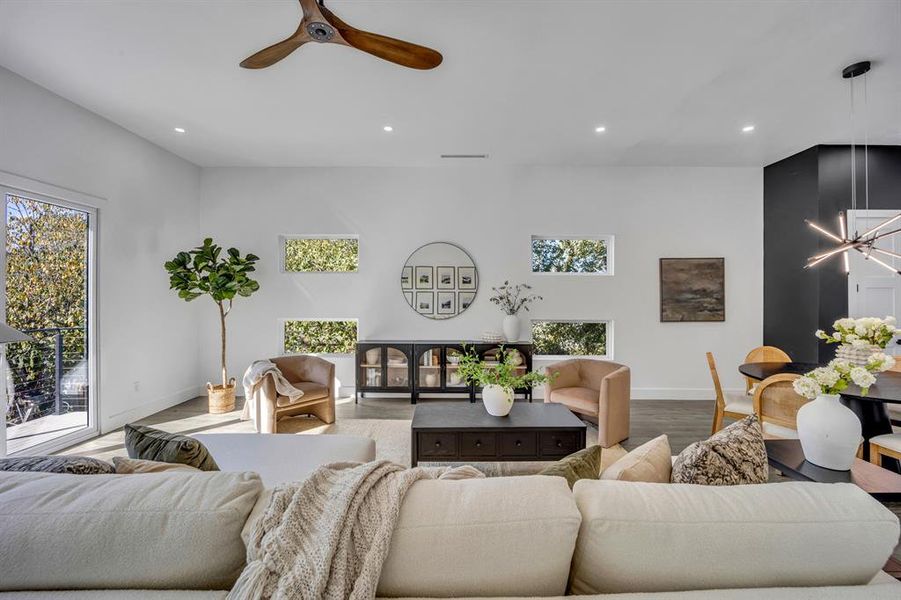 Living room featuring wood-type flooring and ceiling fan with notable chandelier