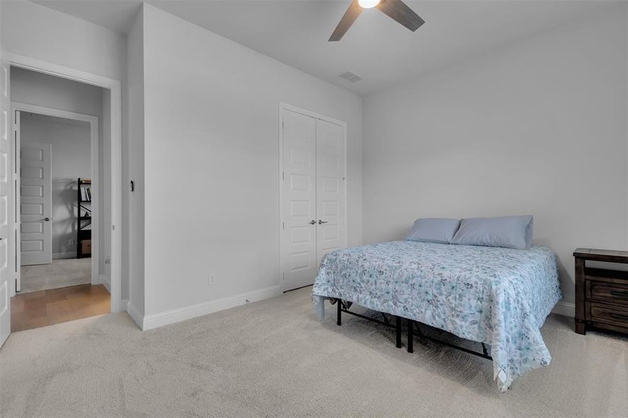 Guest bedroom 1 with ceiling fan and a closet