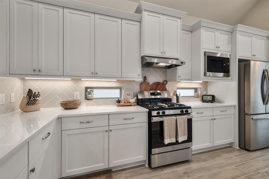 White cabinets, stylish backsplash and remarkable quartz counterstops.