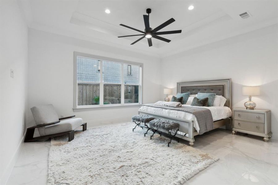 Bedroom with ceiling fan and a tray ceiling