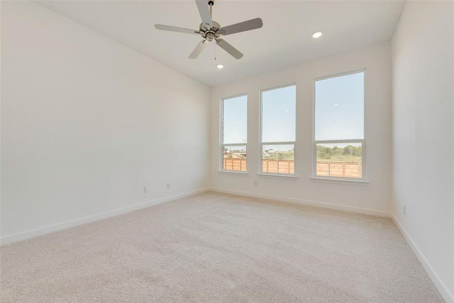 Carpeted spare room featuring ceiling fan