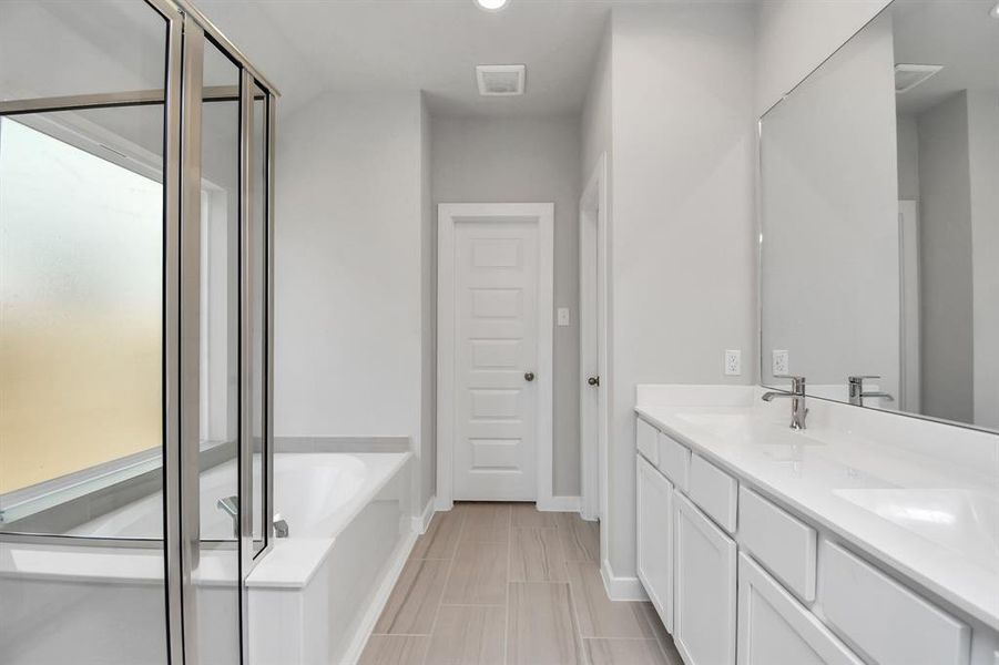 Spa-like retreat within the confines of this primary bathroom. Sample photo of similar plan. As-built color and selections may vary.