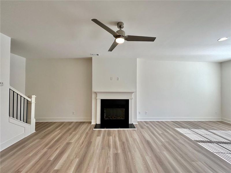 Unfurnished living room with light hardwood / wood-style flooring and ceiling fan