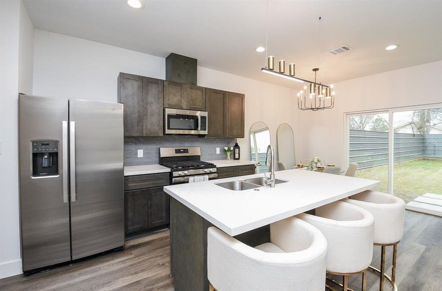 Gorgeous, designer finish dark cabinetry provides nice storage; with smooth quartz counters and attractive subway style tile backsplash, everywhere you step.