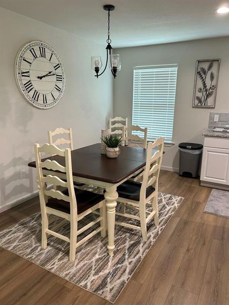 Dining space featuring dark hardwood / wood-style flooring and a notable chandelier