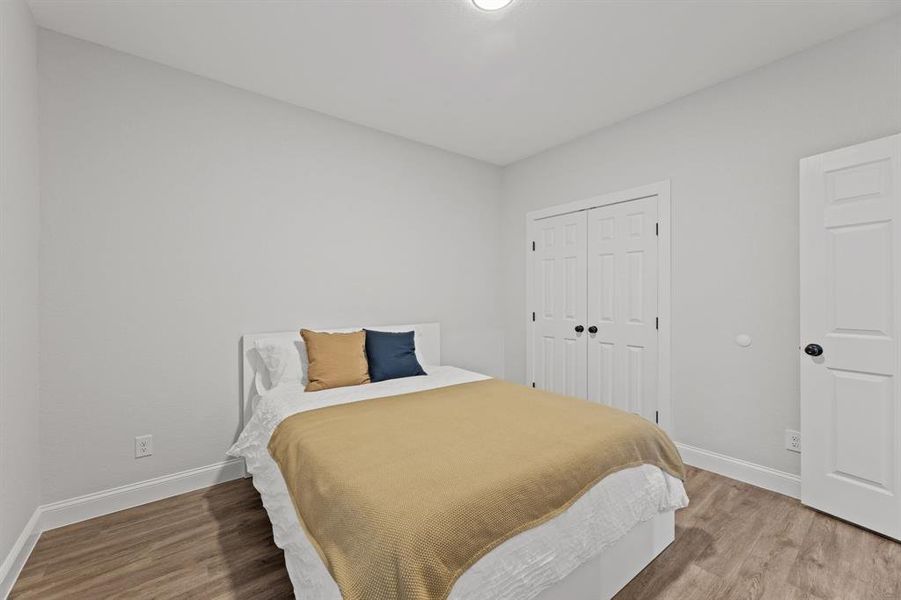 Bedroom with hardwood / wood-style floors and a closet