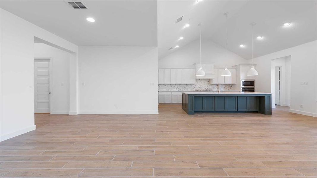 Kitchen with light hardwood / wood-style flooring, white cabinetry, and pendant lighting