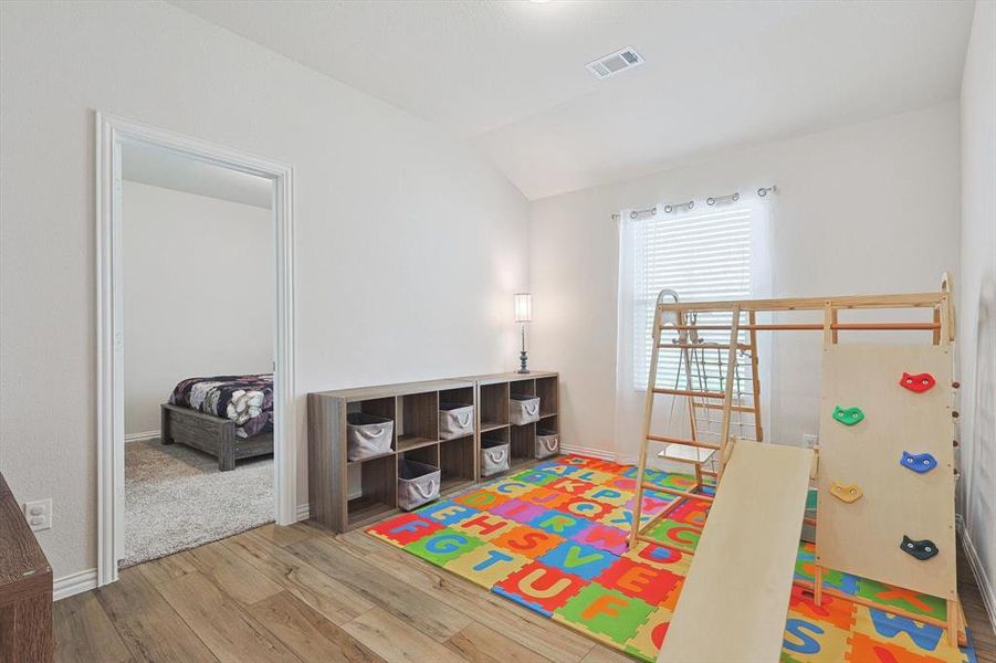 Playroom featuring vaulted ceiling and hardwood / wood-style floors
