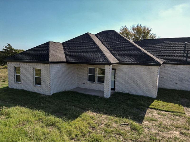 Back of house with a yard and a patio