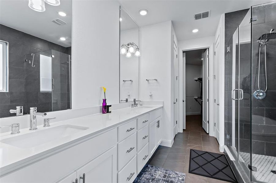 The primary bath is spa-like with the extra long vanity featuring His & Hers sinks and quartz counters