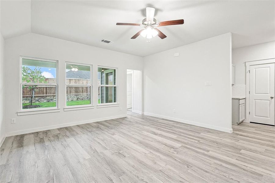 Unfurnished room with lofted ceiling, light wood-type flooring, and ceiling fan