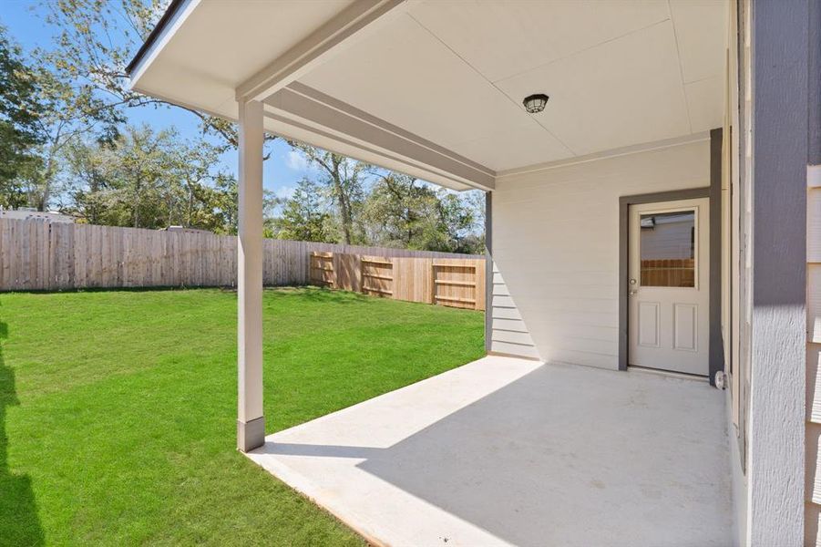 The covered patio is generously sized, providing ample space for various outdoor activities.