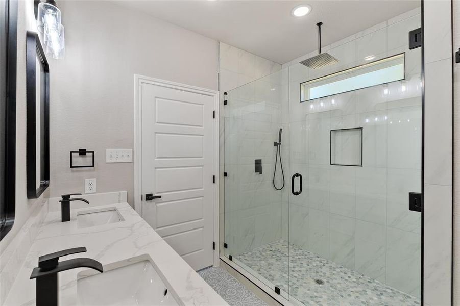 Bathroom with double vanity and a shower with door