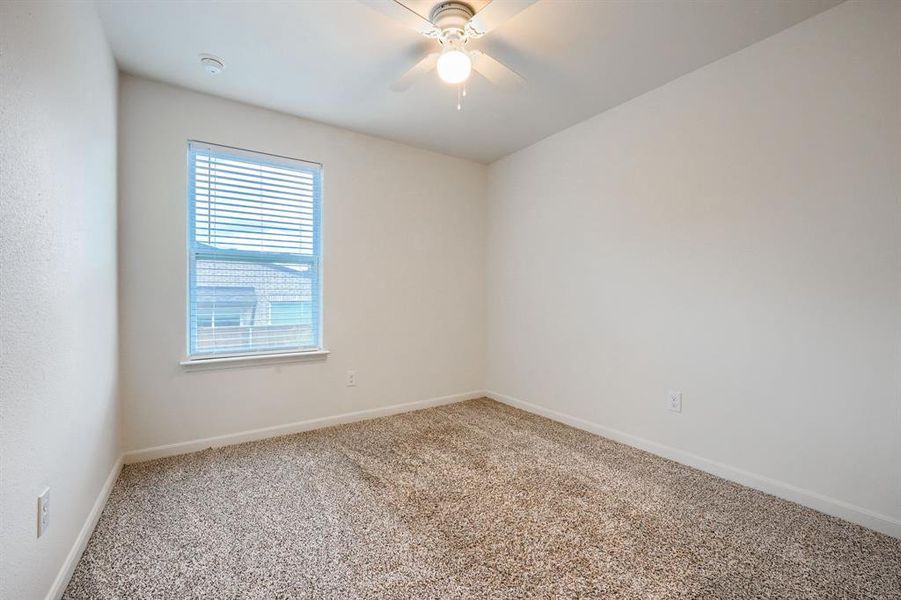 Spare room featuring carpet floors and ceiling fan