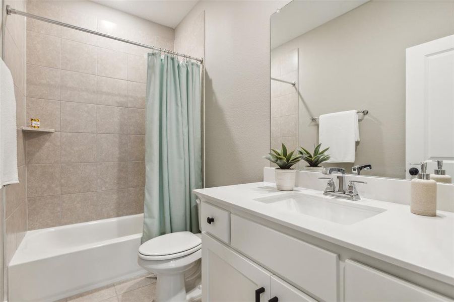 Full bathroom featuring vanity, shower / bath combo, toilet, and tile patterned floors