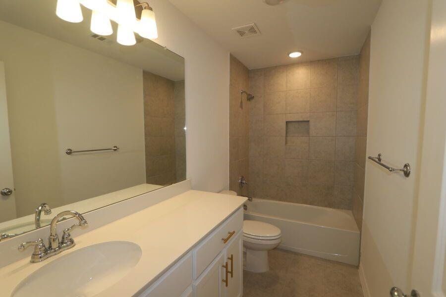 Full bathroom featuring vanity, toilet, and tiled shower / bath combo