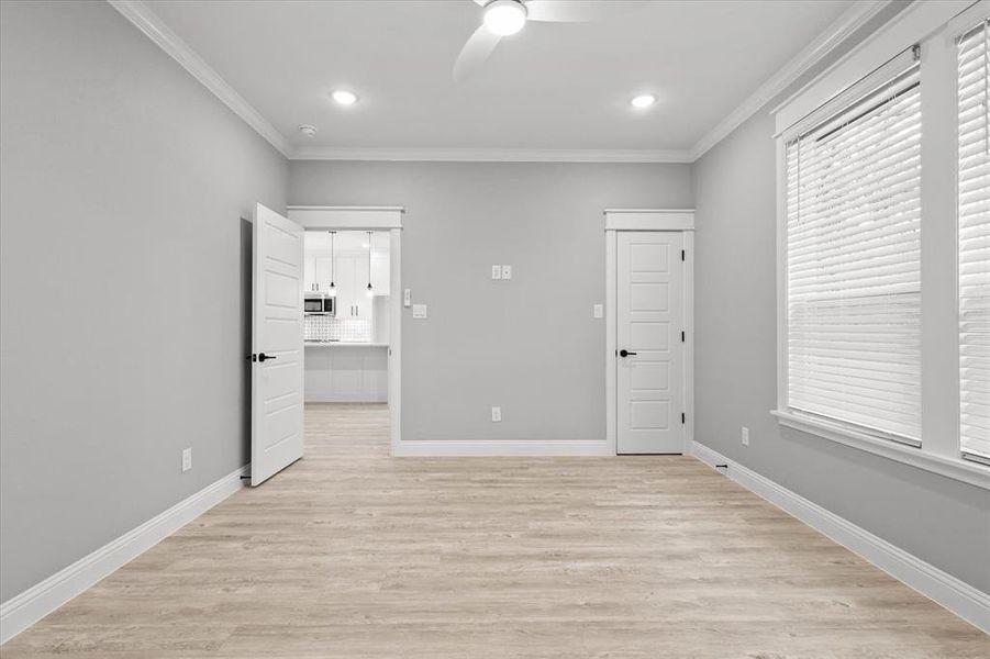 Unfurnished bedroom with ceiling fan, ornamental molding, and light hardwood / wood-style flooring