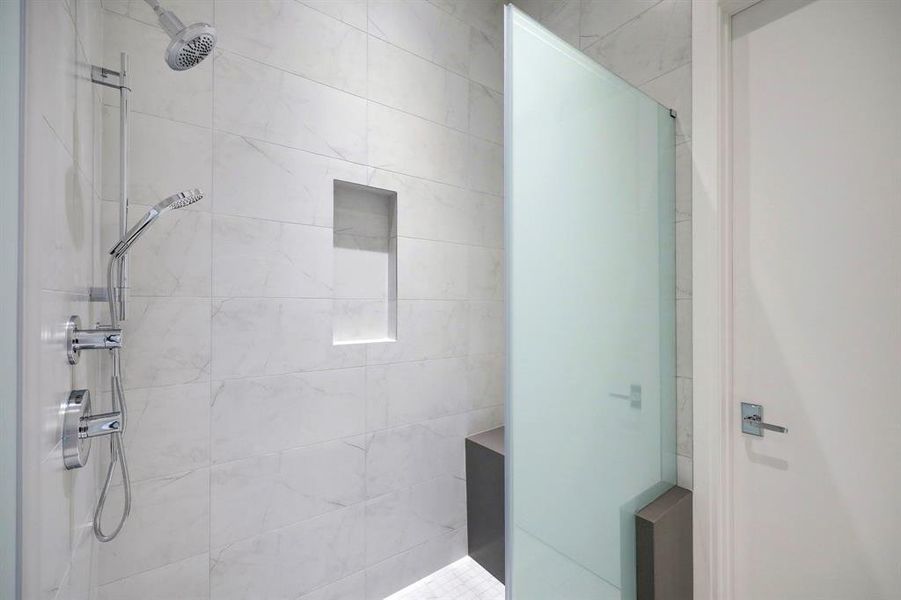 Bench seating, a shampoo niche and floor-to-ceiling tile complete the work-of-art shower.