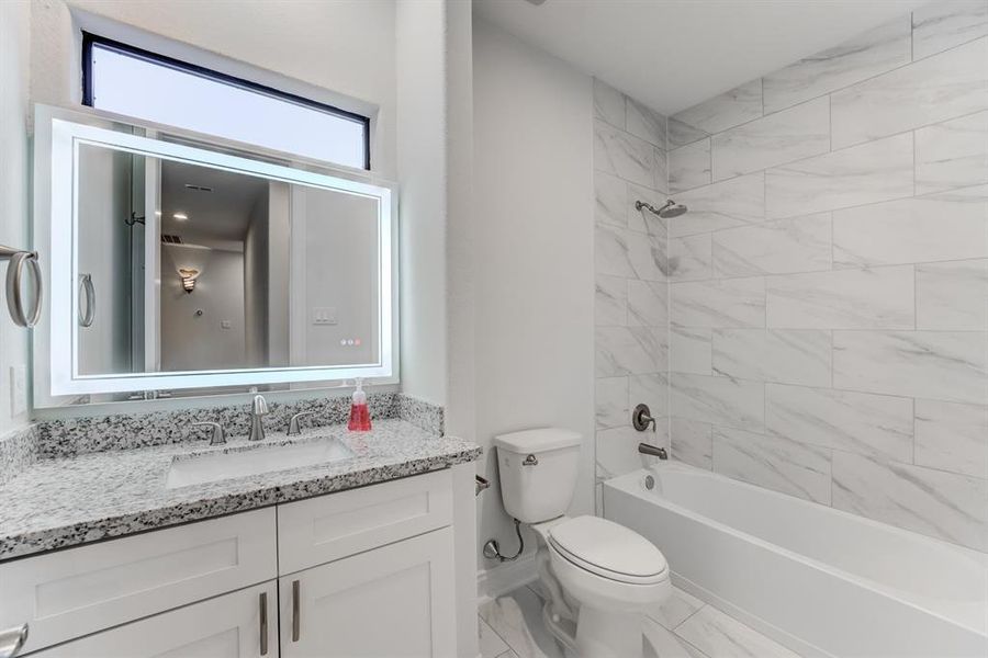 The modern aesthetic continues in the secondary bath downstairs, which features a tub/shower and a transom window for natural light.