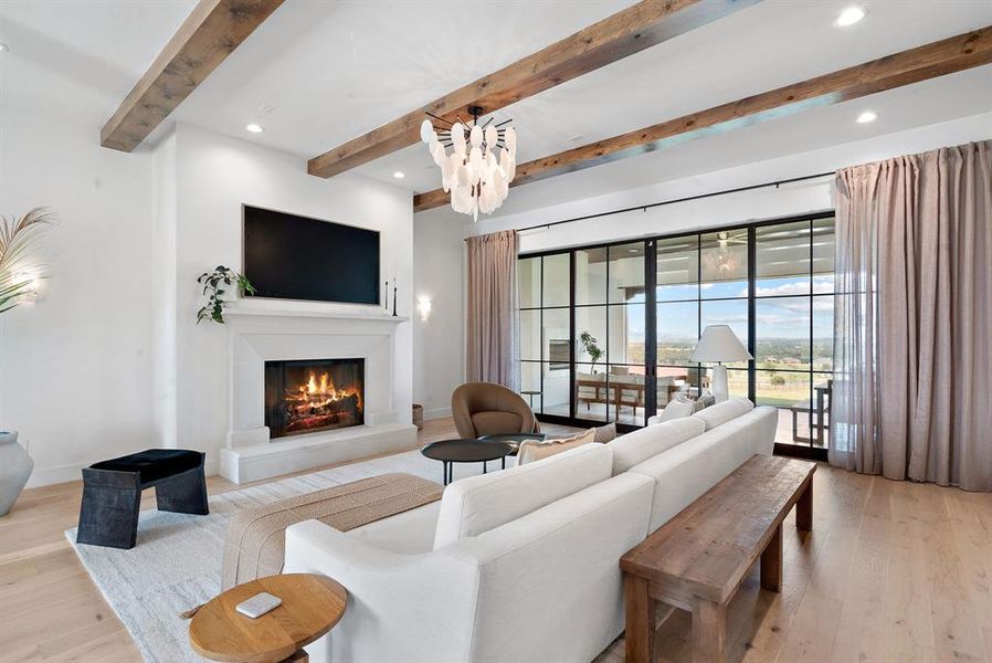 Living room with beam ceiling and light wood-type flooring