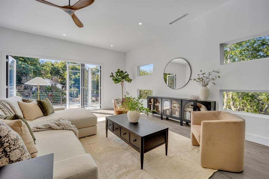 Living room with light hardwood / wood-style floors and ceiling fan