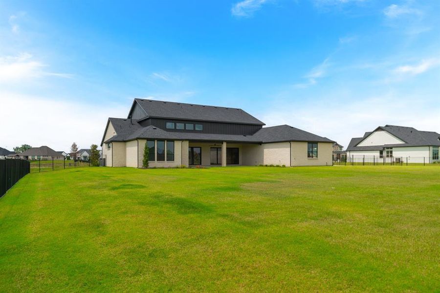 Rear view of house featuring a lawn