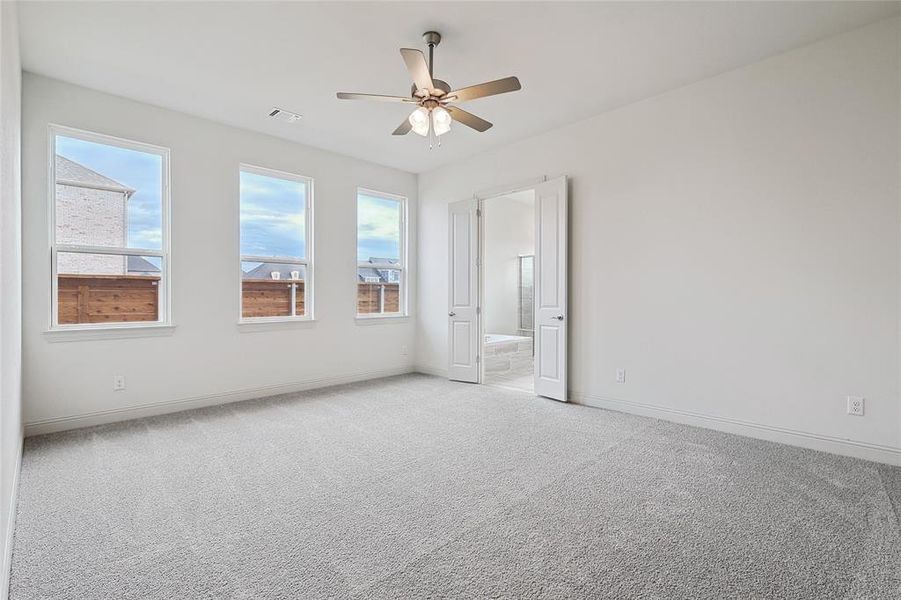 Carpeted spare room with ceiling fan